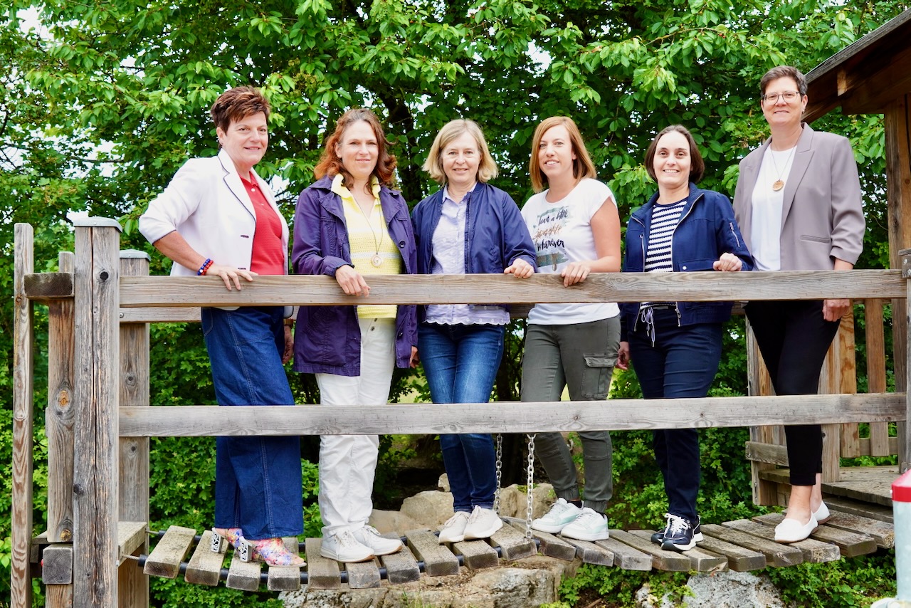 Kollegium der GS Stallwang, 5 Lehrerinnen vor einer grünen Hecke